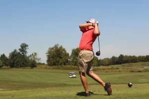 man in pink shirt playing golf