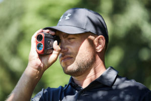 golfer using golf rangefinder with slope